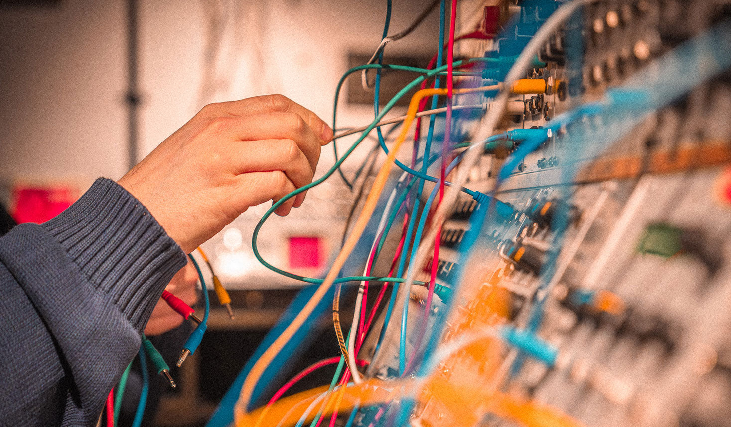 Hands patching modular synthesizer